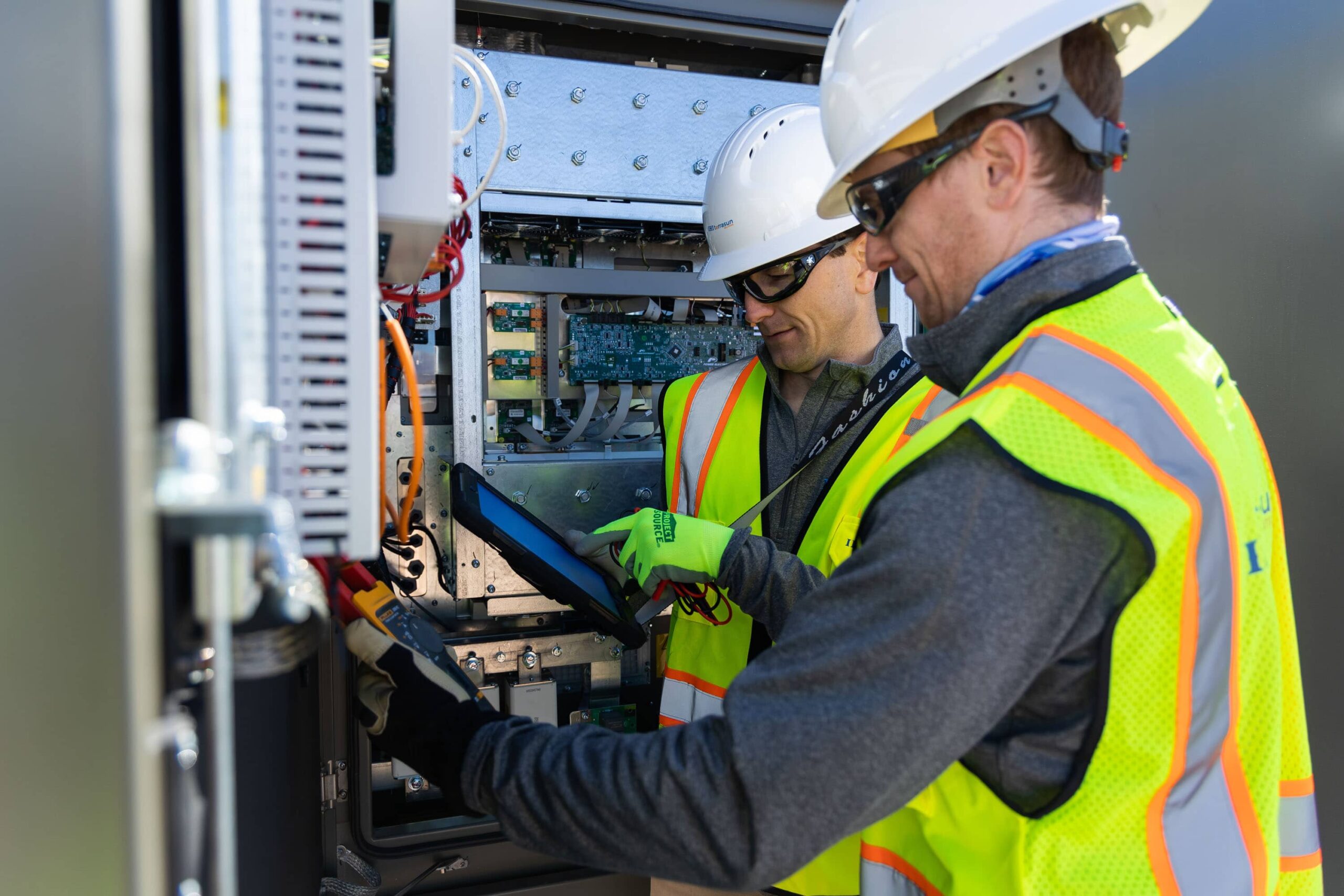 Deux techniciens échangent autour d’une installation électrique