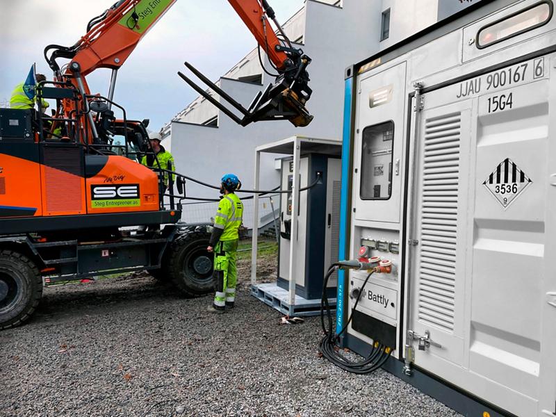 Application constructeur : stockage conteneurisé et chargeur d’engin, équipements distincts.